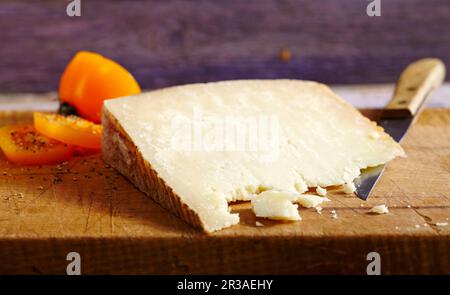 Pecorino sardo, fromage dur à base de lait de brebis (Sardaigne) sur une planche de bois avec un couteau Banque D'Images
