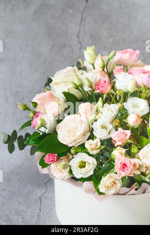 Bouquet de belles fleurs avec des pivoines, des roses et des eustomas dans la boîte cadeau de Papper en face de gre Banque D'Images