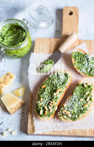 Toasts à la sauce traditionnelle au pesto au basilic italien sur une table en pierre gris clair. Pesto vert avec pin Banque D'Images