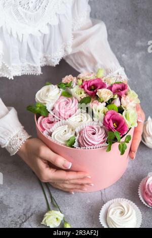 Coffret cadeau dans la boîte - guimauves blanches et roses et belles fleurs sur le grunge gris backgroun Banque D'Images