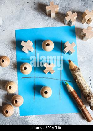 Jeu TIC tac TOE avec des figures en bois sur fond bleu Banque D'Images