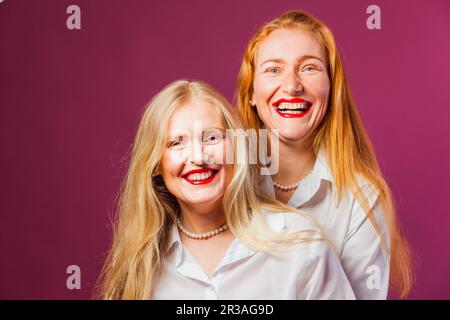 Les filles posant dans des chemises blanches et collier de perles Banque D'Images