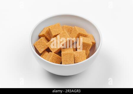 Cubes de sucre de canne brun isolé sur fond blanc Banque D'Images