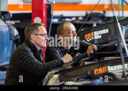 Atelier de réparation et de diagnostic des véhicules automobiles par les mécaniciens en service en ville Banque D'Images