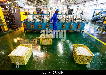 Travailleur d'usine africain sur un métier à tisser de ligne de montage de trame de cobobineuse Banque D'Images