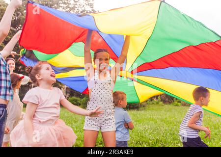 Jeune fille joyeuse tenant une toile colorée sur les enfants Banque D'Images