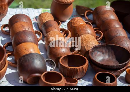 Les tasses et les bols de cuisine en bois sont vendus au salon. Banque D'Images