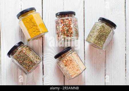 Pots aux épices et herbes variées, sur fond de bois blanc. Banque D'Images