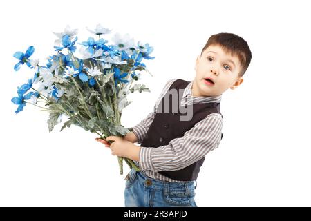 Petit garçon drôle tenant un grand bouquet de fleurs isolées sur fond blanc Banque D'Images