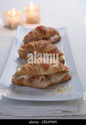 Croissants avec poisson fumé, zeste d'orange et feuilles de fenouil Banque D'Images