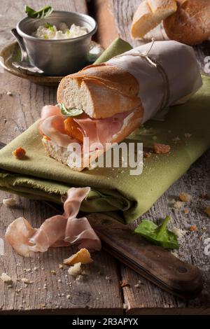 Un sandwich à la baguette avec du jambon de Parme, des épinards et du fromage à la crème Banque D'Images