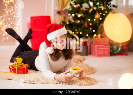 Belle adolescente ouvrant son cadeau de noël Banque D'Images