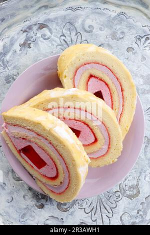 Roulé en éponge avec de la gelée et de la mousse de framboise Banque D'Images
