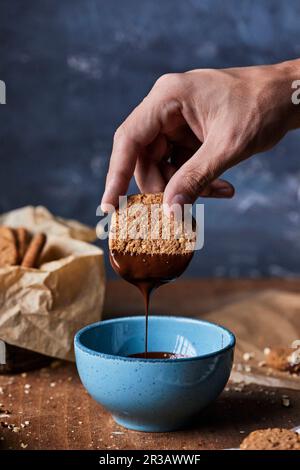 Trempette de biscuit de noyer dans du chocolat fondu Banque D'Images