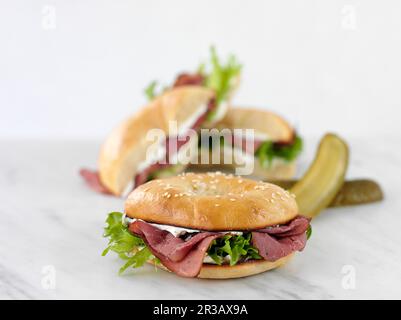 Bagel avec rôti de bœuf, fromage à la crème, laitue et cornichons Banque D'Images