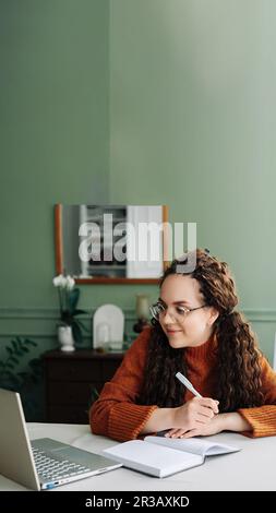 Apprentissage et travail à distance : jeunes étudiantes étudiant en ligne avec un ordinateur portable au bureau à domicile. Éducation en ligne efficace: Jeunes femmes étudiant Learnin Banque D'Images