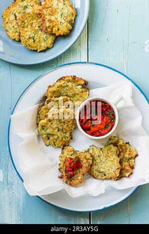 Beignets d'halloumi et de courgettes au poivre rouge et salsa de persil Banque D'Images