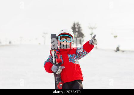 Petit garçon mignon avec skis et une tenue de ski. Un petit skieur dans la station de ski. Vacances d'hiver. Ski Banque D'Images