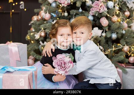 Portrait d'un enfant heureux - garçon et fille. Petits enfants dans les décorations de Noël. Frère et frère Banque D'Images