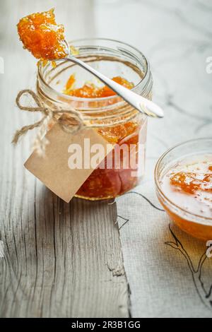 Confiture d'abricot sur fond rustique en bois. Pot de fruits marmelade maison. Pot en verre avec confiture de fruits Banque D'Images