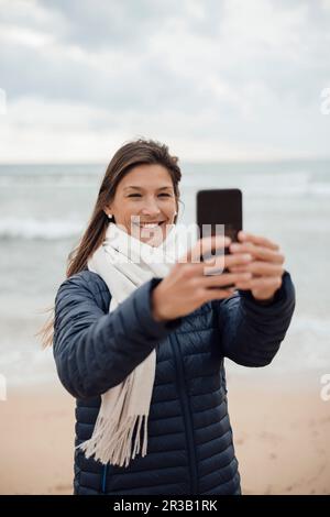 Bonne femme prenant le selfie sur la plage Banque D'Images