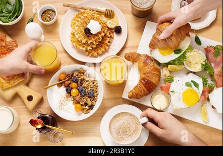 Petit déjeuner sain le dimanche avec croissants, gaufres, granola et sandwichs Banque D'Images