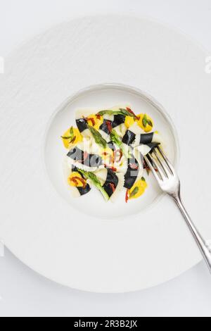 Farfalle noir et blanc aux asperges, tomates séchées et sauce au fromage jaune Banque D'Images