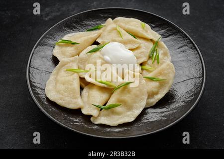 boulettes ukrainiennes authentiques avec pommes de terre, crème aigre et oignons verts Banque D'Images