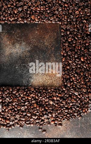 Grains de café noirs en studio. Grains de café fraîchement torréfiés comme fond de texture. Cadre de café Banque D'Images