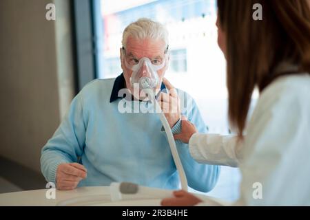 Médecin assistant le patient portant un nébuliseur à la clinique Banque D'Images