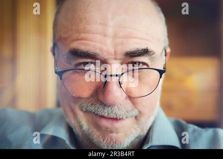 Homme senior souriant portant des lunettes Banque D'Images