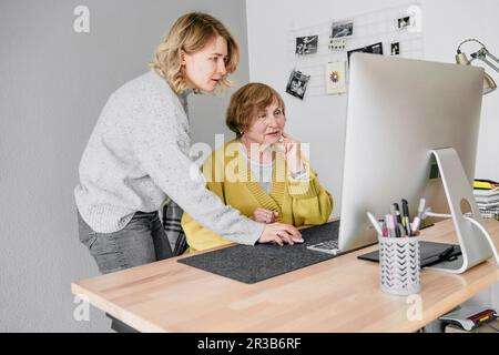 Grand-mère et petite-fille utilisant l'ordinateur à la maison Banque D'Images