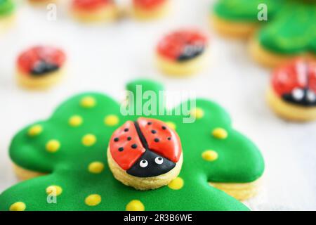 Des coccinelles sur des biscuits au trèfle chanceux Banque D'Images