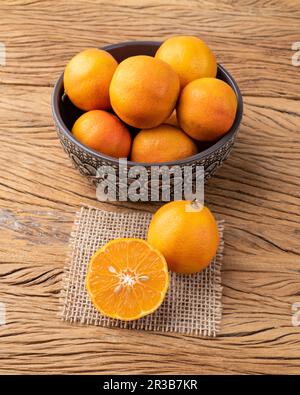 CRAVO ou citrons roses dans un bol sur une table en bois. Banque D'Images