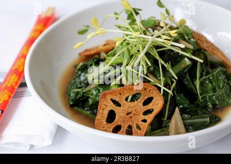 Légumes verts à la moutarde conservés, gingembre, bouillon maison de qualité supérieure avec garniture de copeaux de lotus Banque D'Images