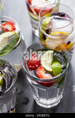 Divers verres d'eau remplis de fruits, de menthe et de gingembre Banque D'Images