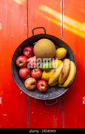 Pommes, citrons, bananes et melon dans un bol de fruits Banque D'Images