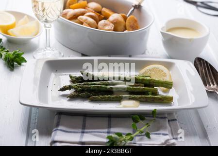 Asperges vertes grillées avec sauce végétalienne hollandaise et mini-pommes de terre rôties Banque D'Images