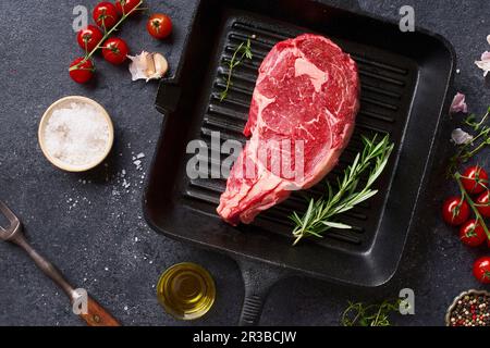 Filet de bœuf Black Angus sur une poêle à frire en fonte, avec romarin frais, thym, huile d'olive, ail et épices Banque D'Images