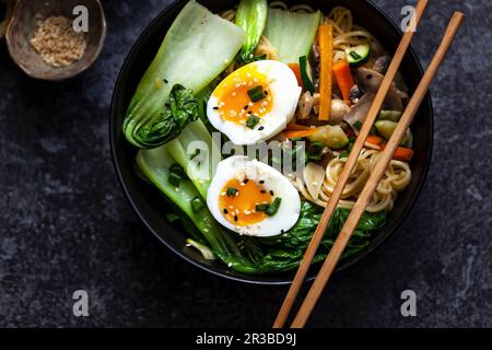 Soupe de nouilles aux carottes, champignons, pak choi, œufs et graines de sésame (Asie) Banque D'Images