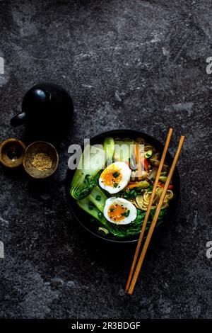 Soupe de nouilles aux carottes, champignons, pak choi, œufs et graines de sésame (Asie) Banque D'Images