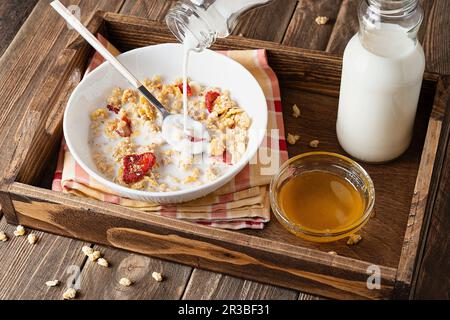 Le lait est versé sur les muesli Banque D'Images