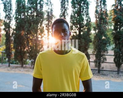 Athlète portant un t-shirt jaune devant les arbres Banque D'Images