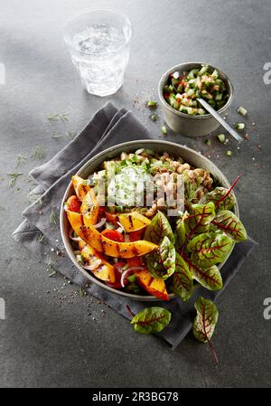 Bol de légumes avec lentilles, feuilles de salade et citrouille Banque D'Images