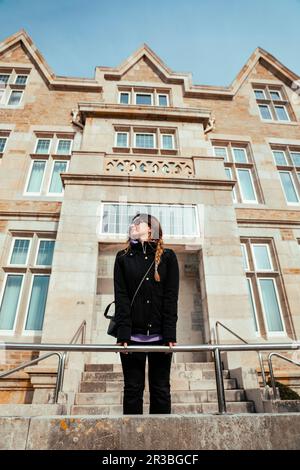 Jeune femme penchée sur une balustrade devant le Palacio de la Magdalena Banque D'Images