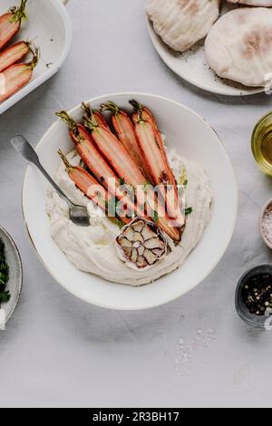 Houmous aux carottes rôties, pain pitta et ail Banque D'Images