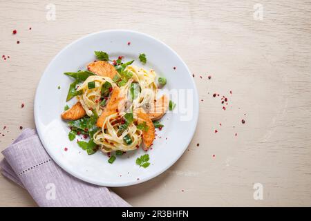 Tagliatelle au saumon, pois mange-tout et oignons de printemps Banque D'Images