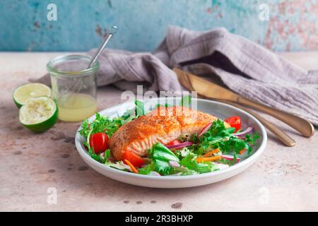 Filet de saumon frit sur une salade de feuilles mélangées Banque D'Images