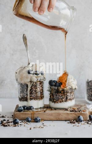 Granola au yaourt dans un pot avec crème glacée à la banane aux myrtilles et sirop d'érable Banque D'Images