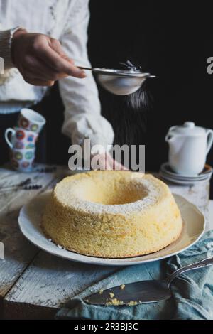 Étendre le sucre sur le gâteau de mousseline Banque D'Images